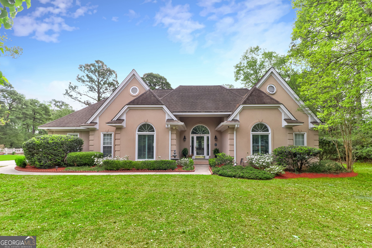a front view of house with yard and green space
