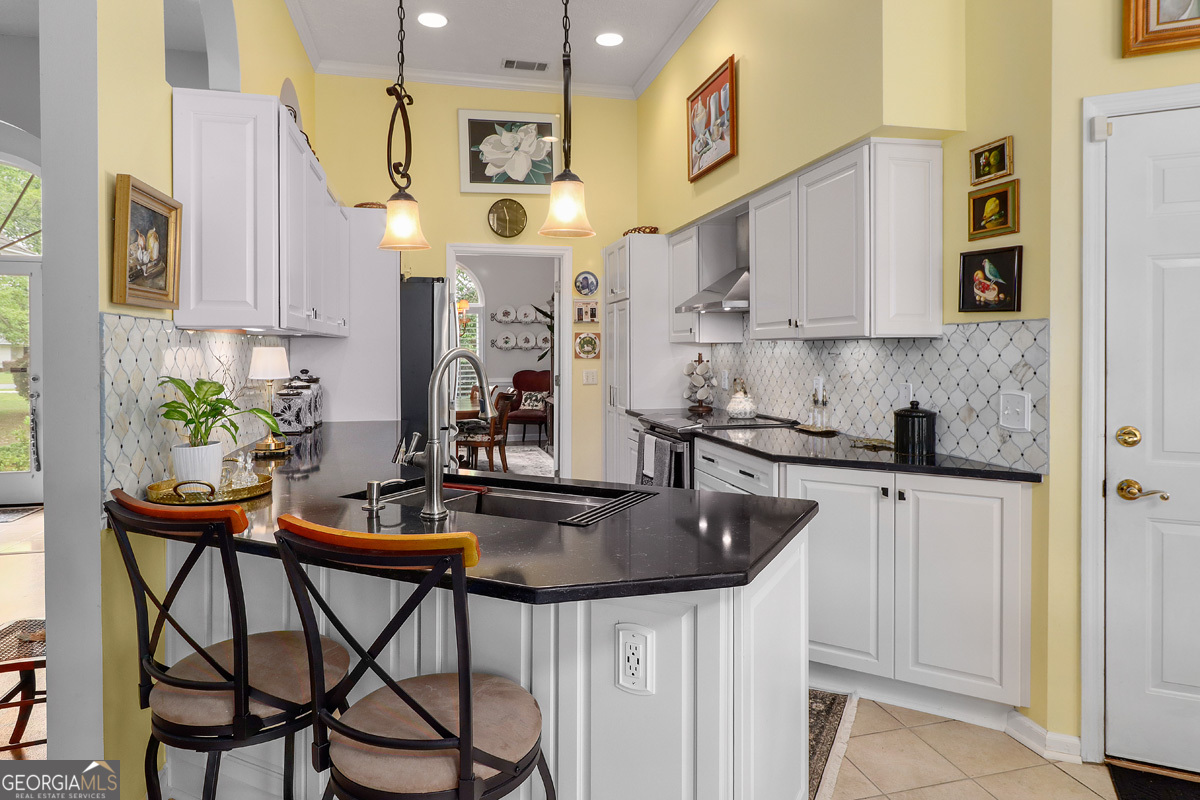 109 St Andrews Road Rincon, GA 31326 - Photo 22 of 52 a kitchen with stainless steel appliances kitchen island a table chairs sink and cabinets