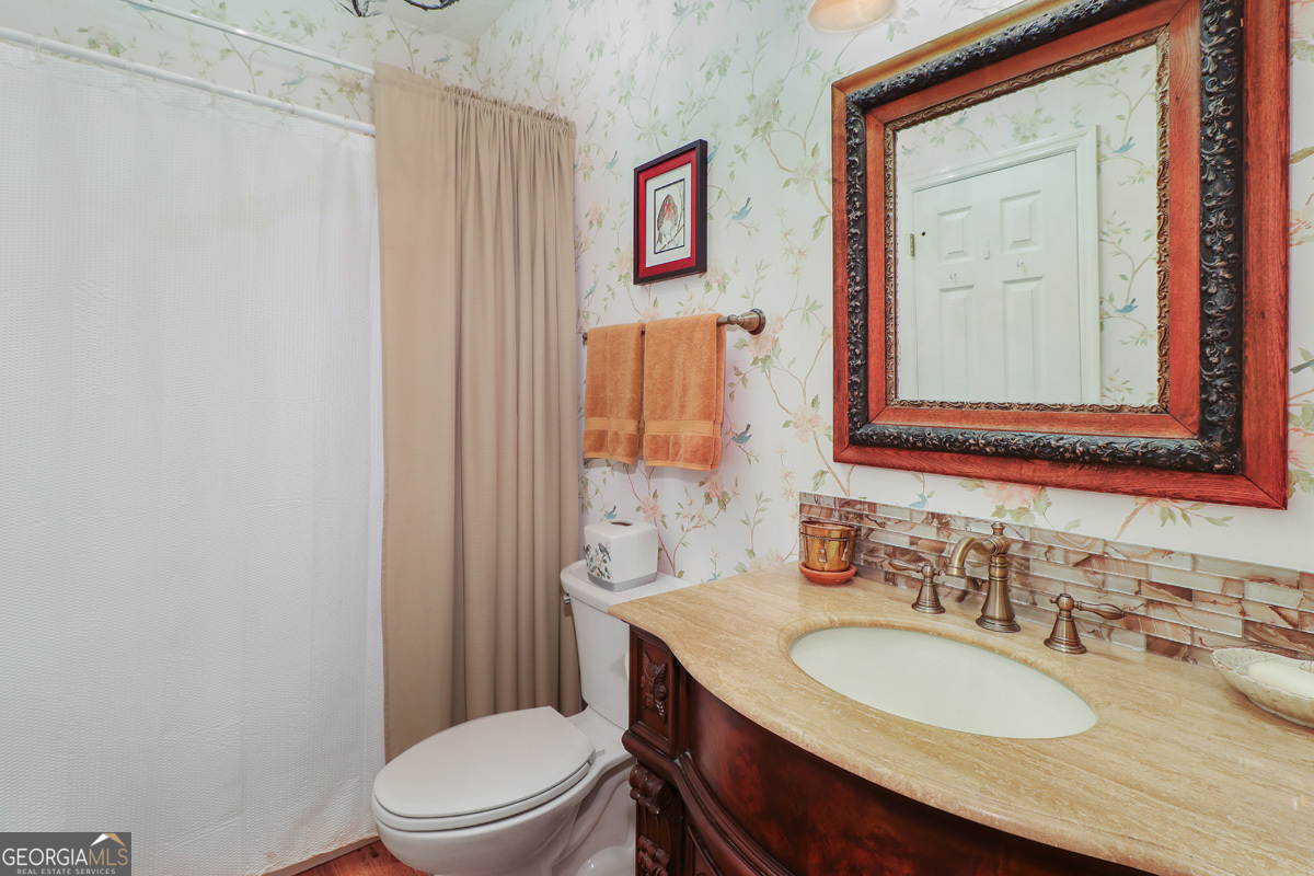 109 St Andrews Road Rincon, GA 31326 - Photo 33 of 52 a bathroom with a granite countertop toilet a sink and a mirror