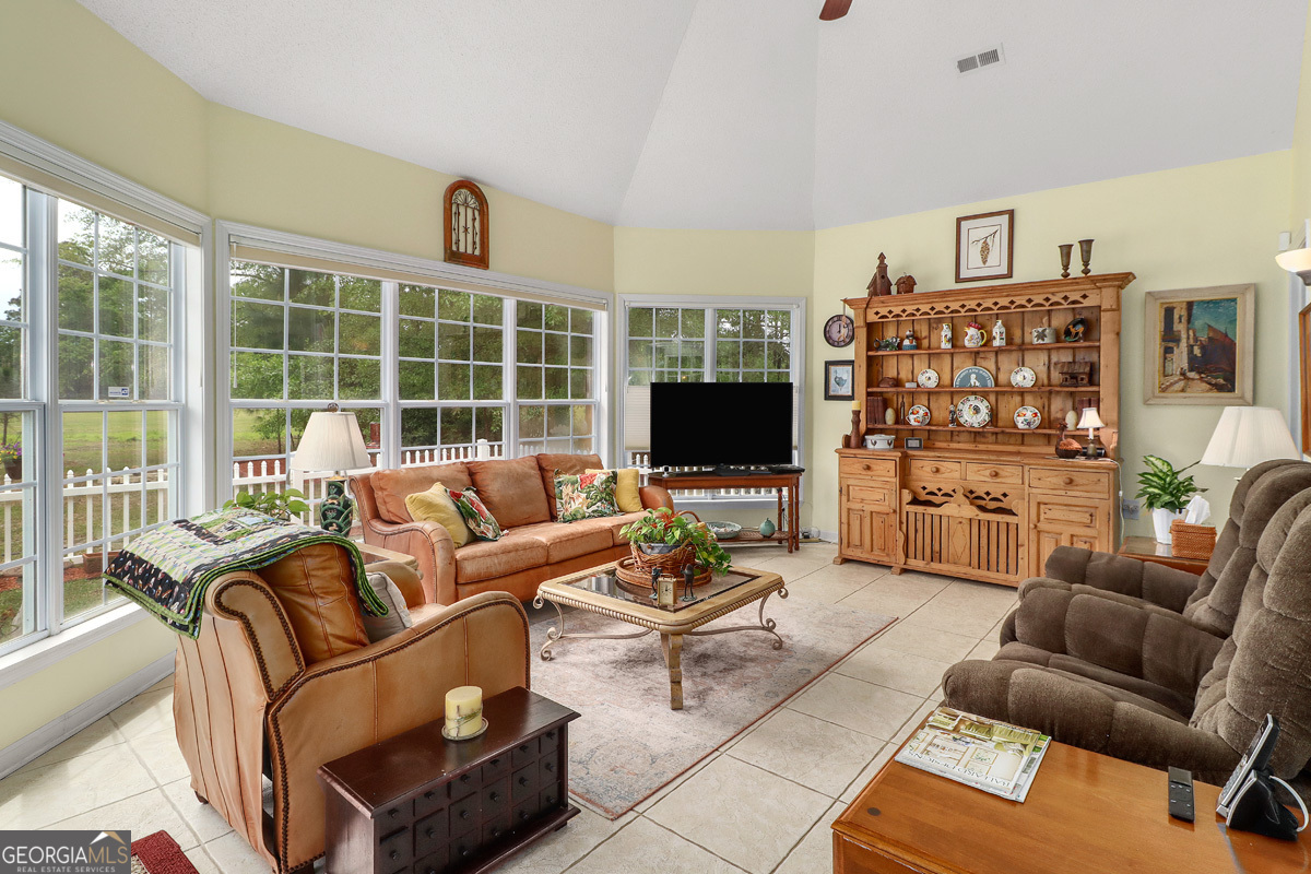 109 St Andrews Road Rincon, GA 31326 - Photo 42 of 52 a living room with furniture a flat screen tv and a floor to ceiling window