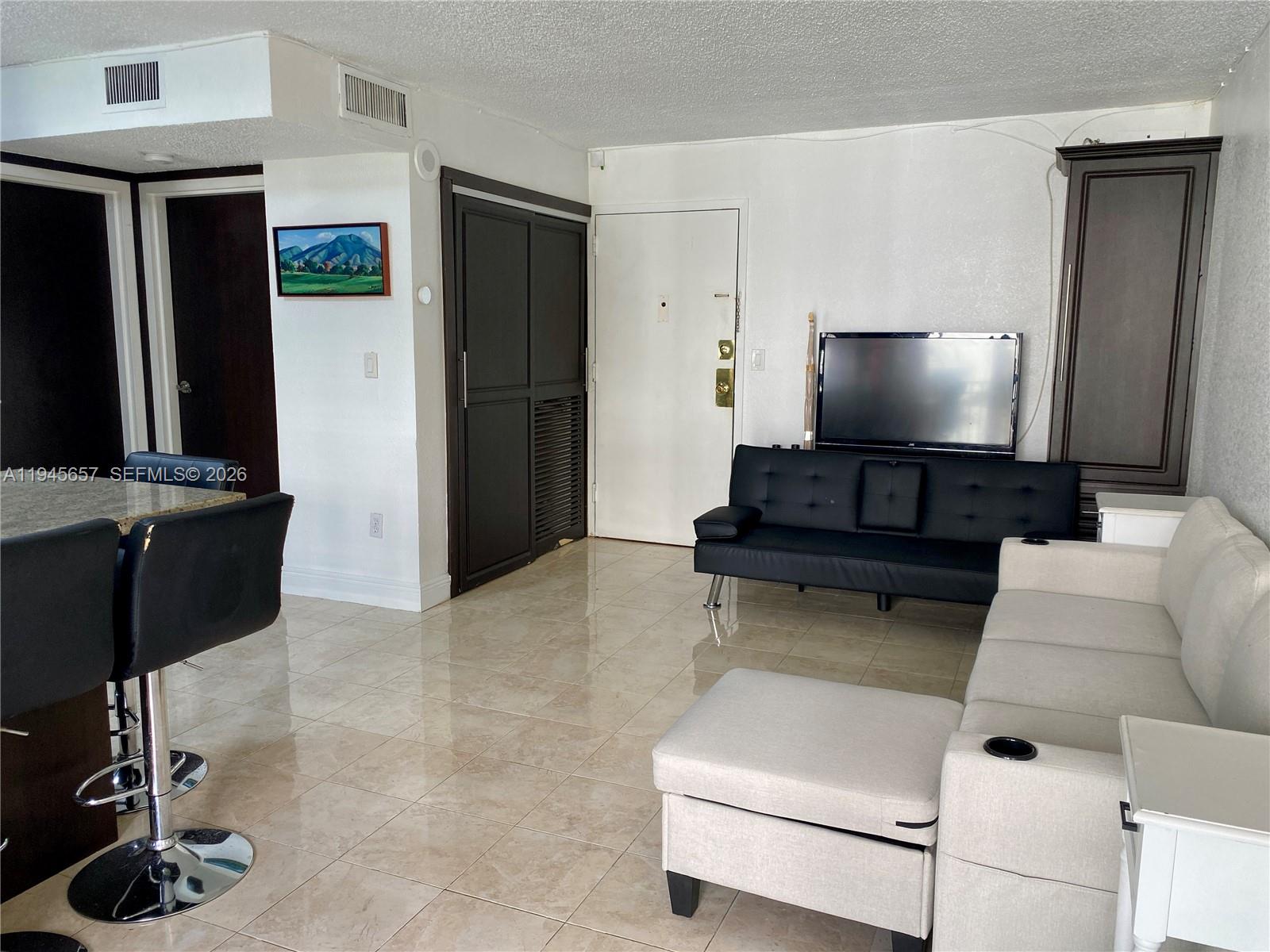 17011 North Bay Road, Unit 304 Sunny Isles Beach, FL 33160 - Photo 25 of 54 a living room with furniture and a flat screen tv
