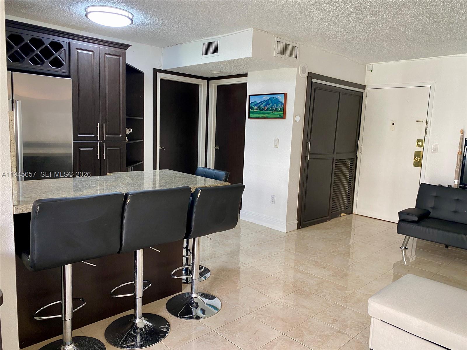 17011 North Bay Road, Unit 304 Sunny Isles Beach, FL 33160 - Photo 26 of 54 a kitchen with stainless steel appliances kitchen island granite countertop a refrigerator and a sink