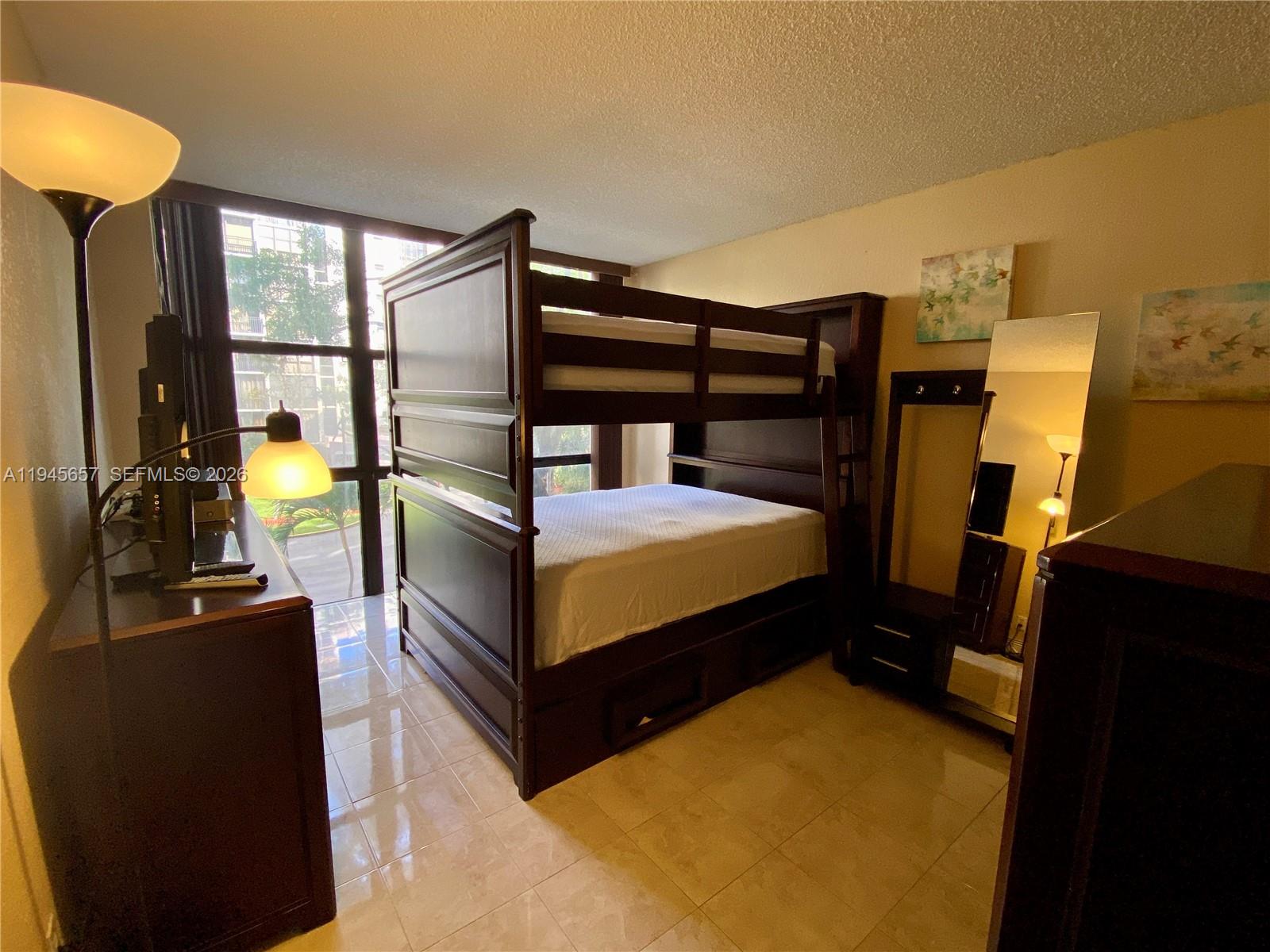 17011 North Bay Road, Unit 304 Sunny Isles Beach, FL 33160 - Photo 28 of 54 a bedroom with a bed and wooden floor