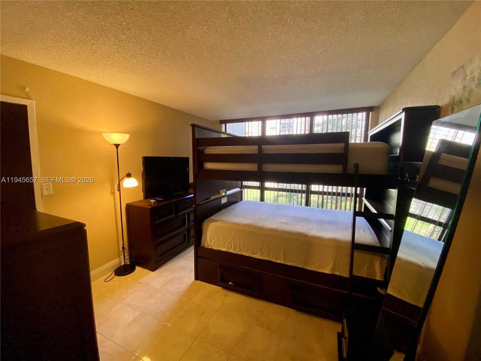17011 North Bay Road, Unit 304 Sunny Isles Beach, FL 33160 - Photo 32 of 54 a bed room with furniture and a flat screen tv