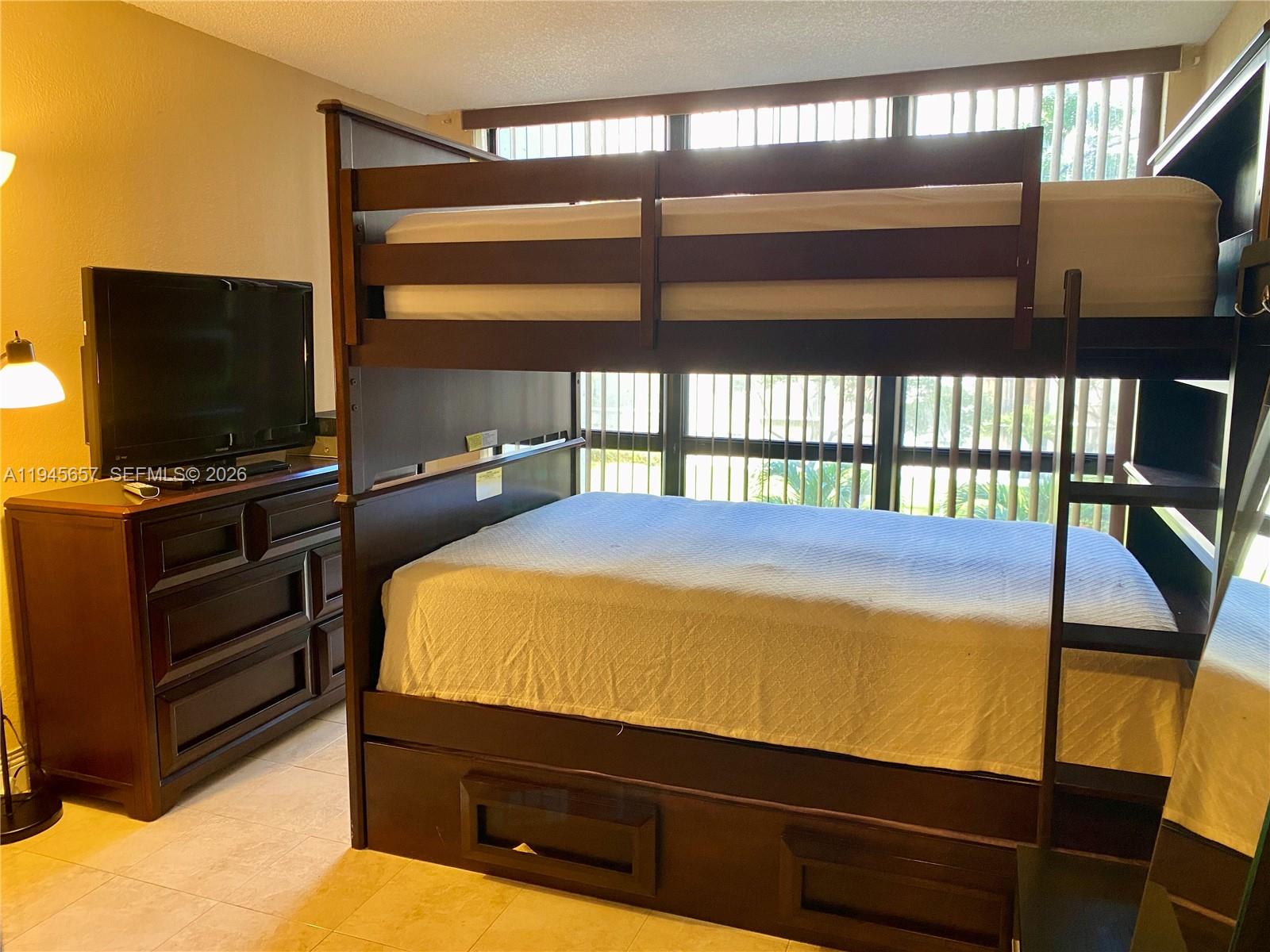 17011 North Bay Road, Unit 304 Sunny Isles Beach, FL 33160 - Photo 35 of 54 a bedroom with bunk bed and a window