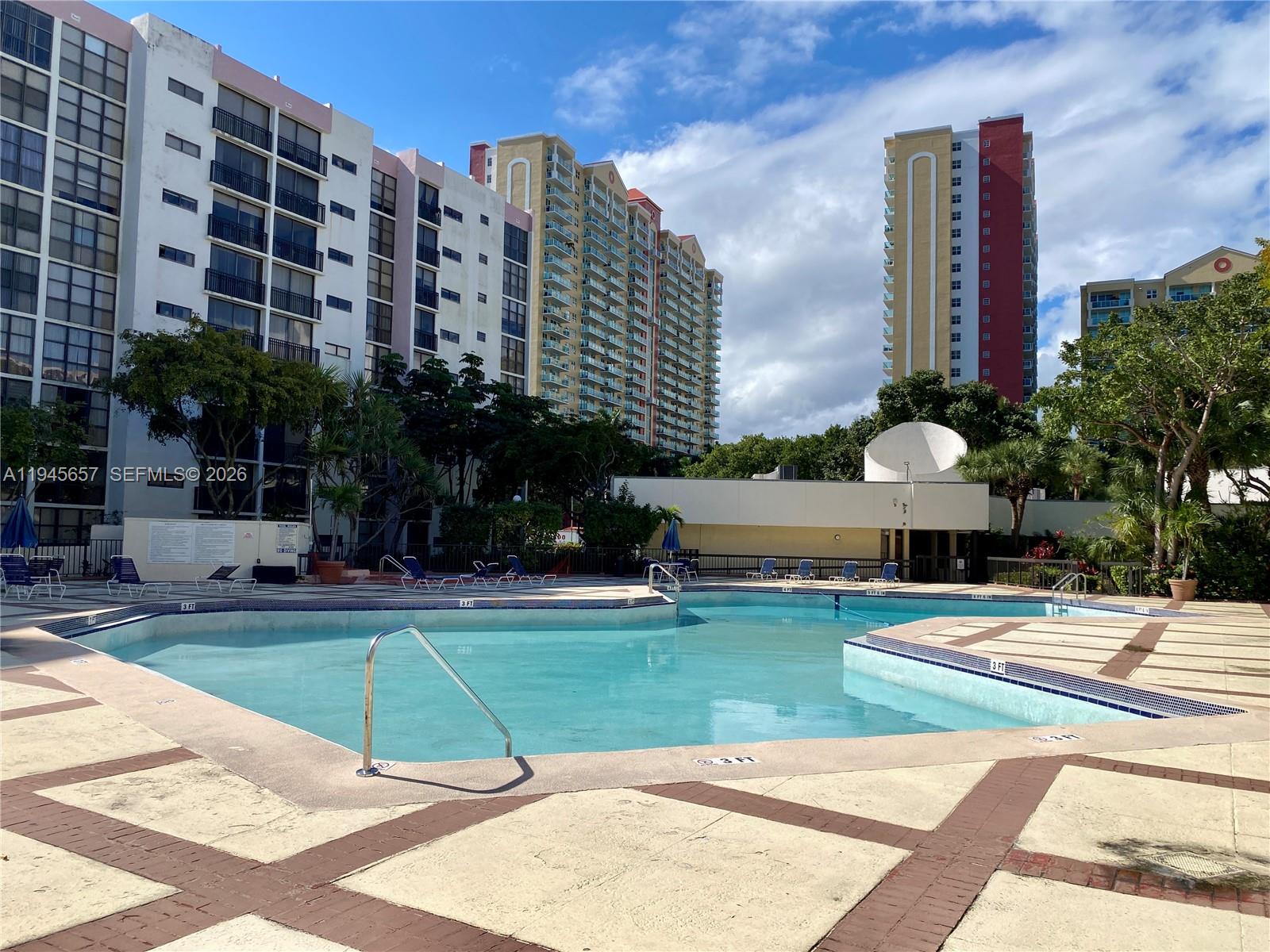 17011 North Bay Road, Unit 304 Sunny Isles Beach, FL 33160 - Photo 48 of 54 a view of a tall building next to a yard