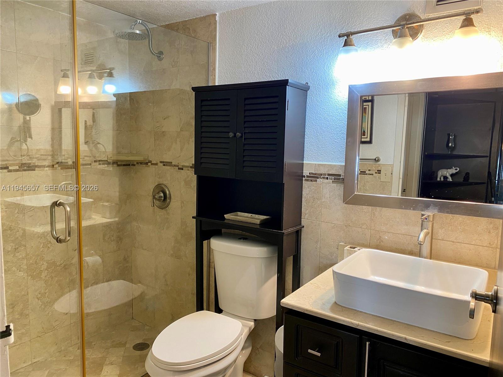 17011 North Bay Road, Unit 304 Sunny Isles Beach, FL 33160 - Photo 5 of 54 a bathroom with a sink a toilet and shower