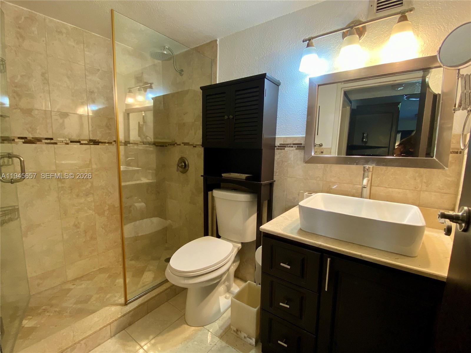 17011 North Bay Road, Unit 304 Sunny Isles Beach, FL 33160 - Photo 6 of 54 a bathroom with a sink a toilet and shower