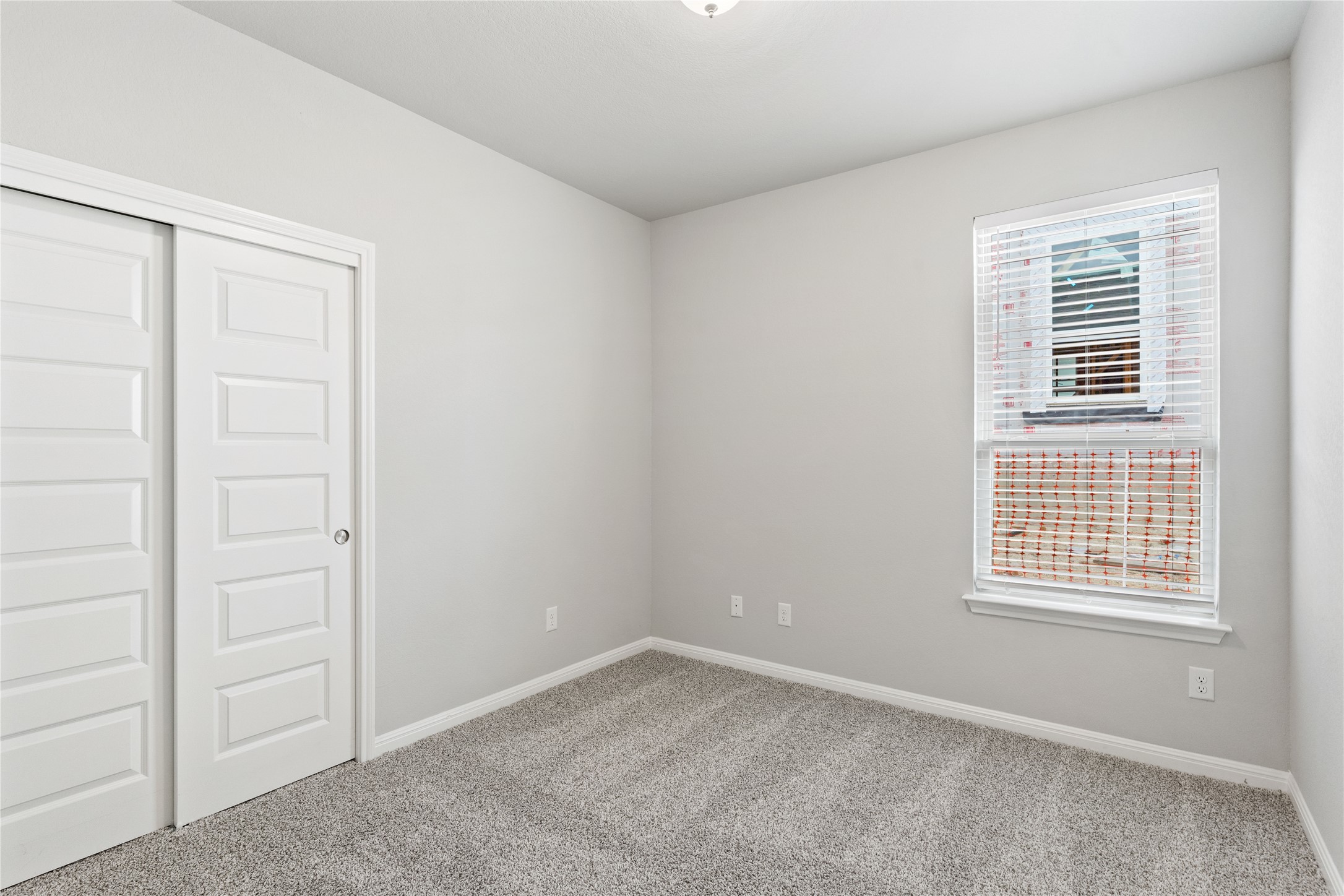 313 Mclintock Road Jarrell, TX 76537 - Photo 8 of 17 A well-lit bedroom features plush carpeting and a sliding closet door.