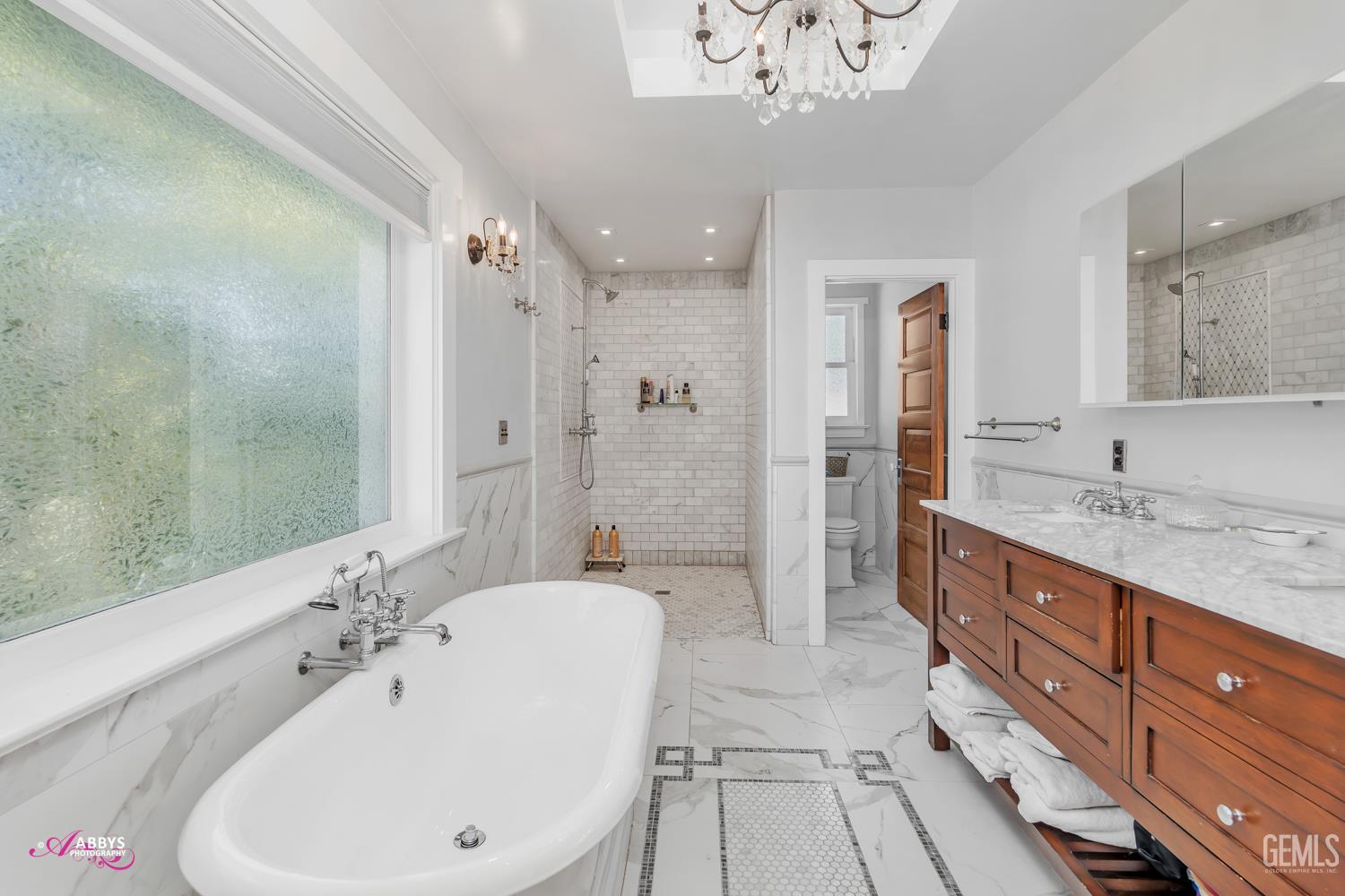 Undisclosed Address Bakersfield, CA 93301 - Photo 26 of 58 a spacious bathroom with a bathtub shower sink and mirror