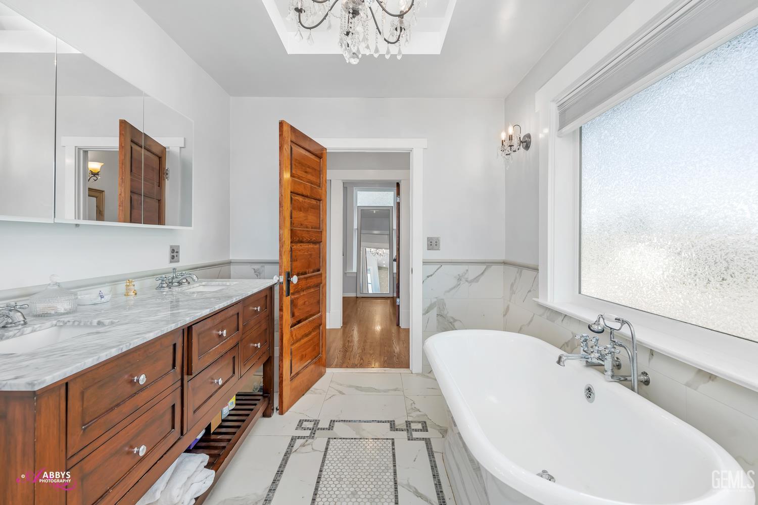 Undisclosed Address Bakersfield, CA 93301 - Photo 28 of 58 a spacious bathroom with a double vanity sink double mirror and bathtub