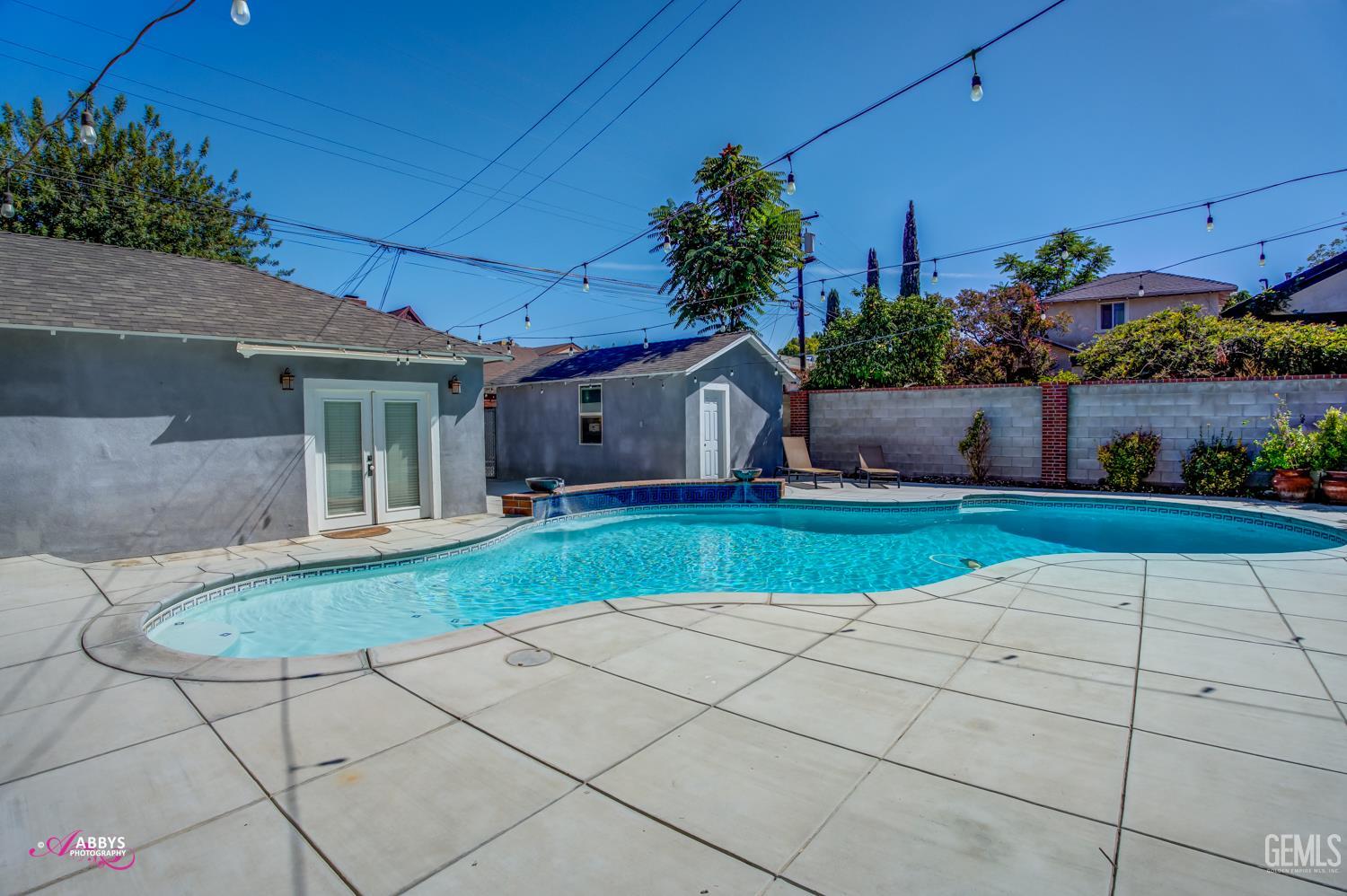 Undisclosed Address Bakersfield, CA 93301 - Photo 46 of 58 a front view of a house with a yard and potted plants