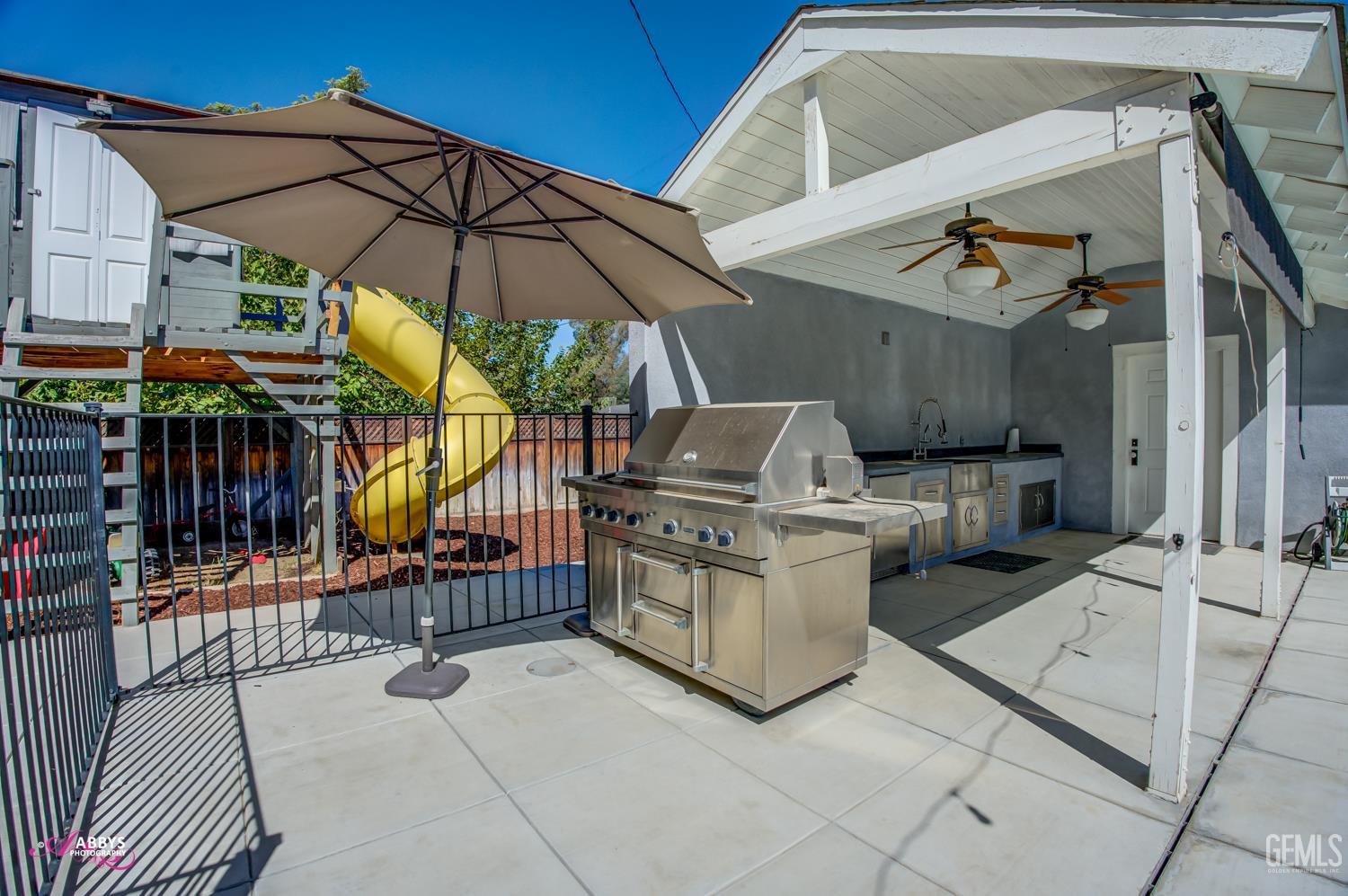 Undisclosed Address Bakersfield, CA 93301 - Photo 49 of 58 a view of a patio with a table and chairs under an umbrella