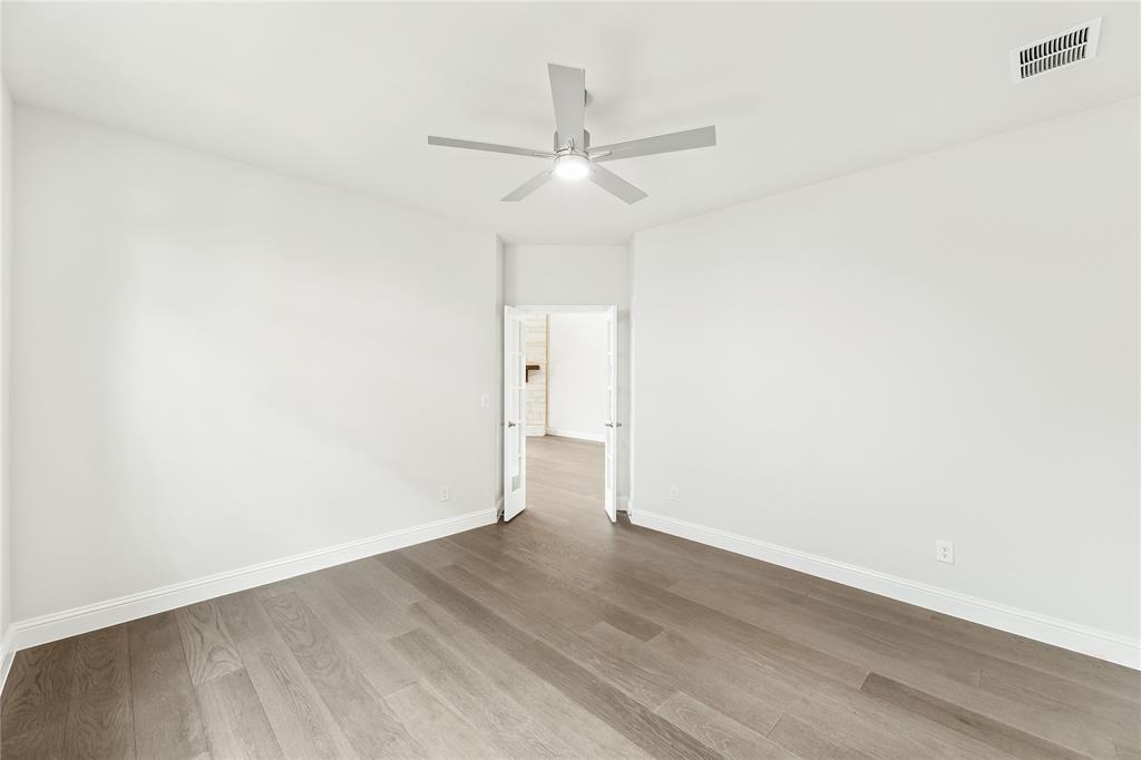 3002 Wild River Road Melissa, TX 75454 - Photo 13 of 36 an empty room with wooden floor ceiling fan and window