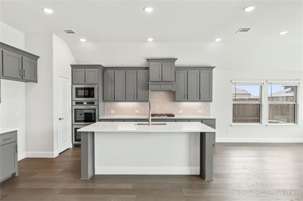 3002 Wild River Road Melissa, TX 75454 - Photo 14 of 36 a kitchen with kitchen island stainless steel appliances a stove refrigerator sink and cabinets