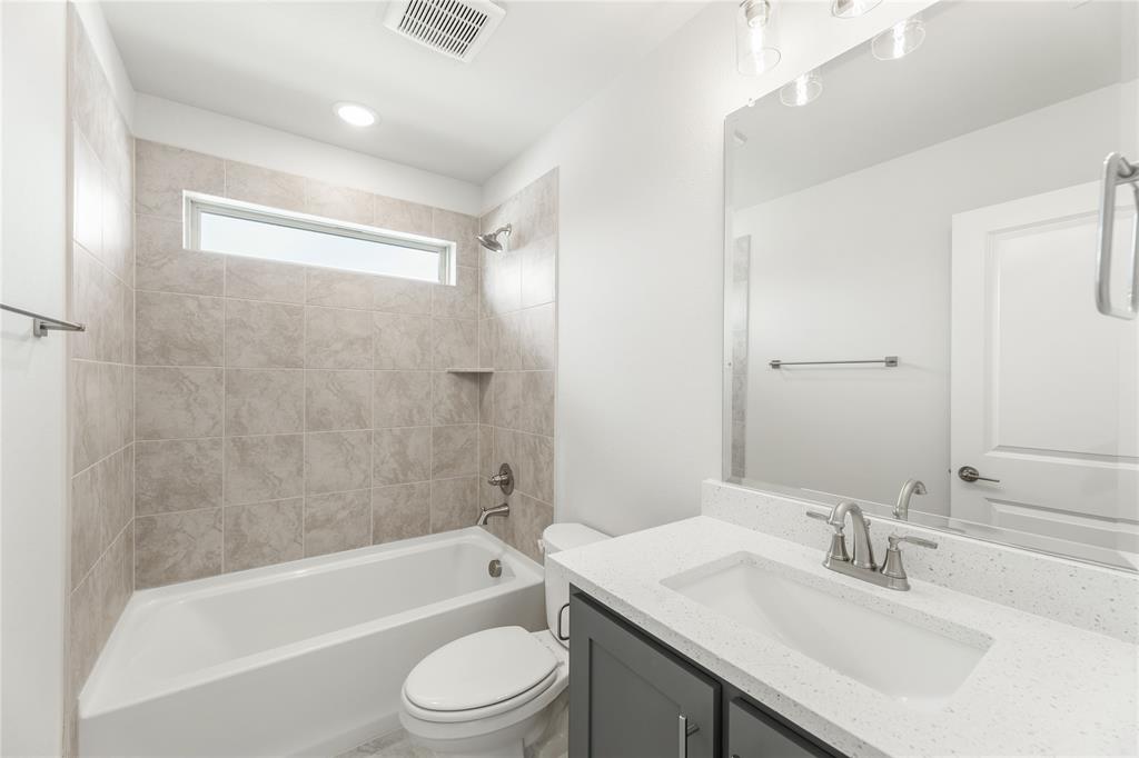 3002 Wild River Road Melissa, TX 75454 - Photo 28 of 36 a bathroom with a granite countertop bathtub shower sink vanity mirror and toilet