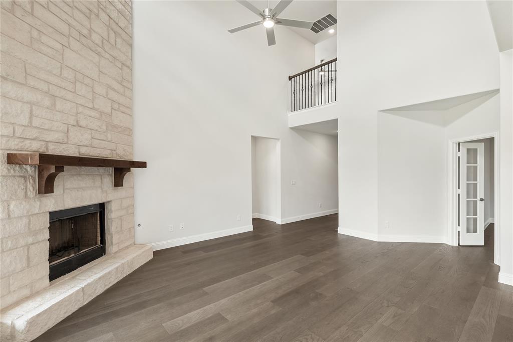 3002 Wild River Road Melissa, TX 75454 - Photo 9 of 36 a view of an empty room with wooden floor and a fireplace
