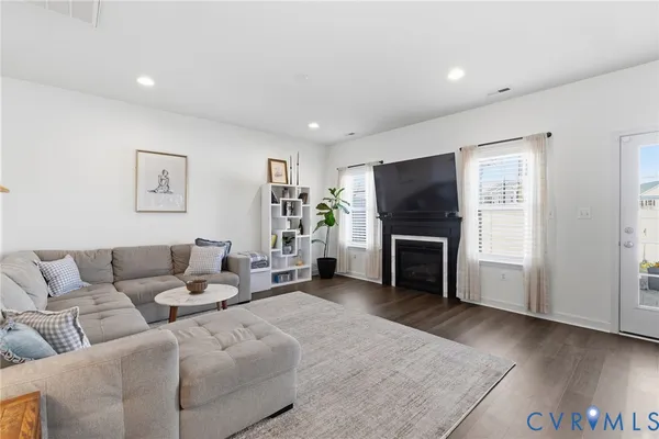 a living room with furniture a fireplace and a flat screen tv
