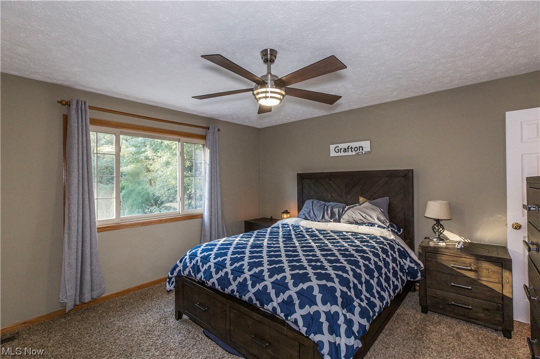 1804 Grace Road Akron, OH 44312 - Photo 7 of 15 Bedroom with ceiling fan, carpet floors, and a textured ceiling