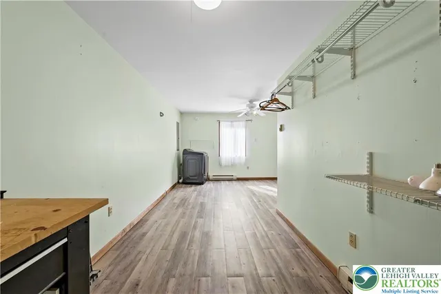 a view of an empty room and a ceiling fan & window