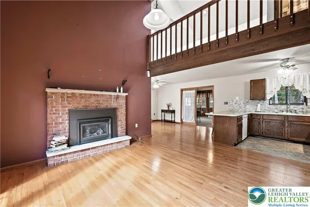 a view of an empty room with a fireplace and a window