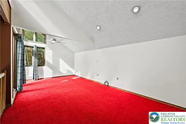 an empty room with closet and a chandelier fan