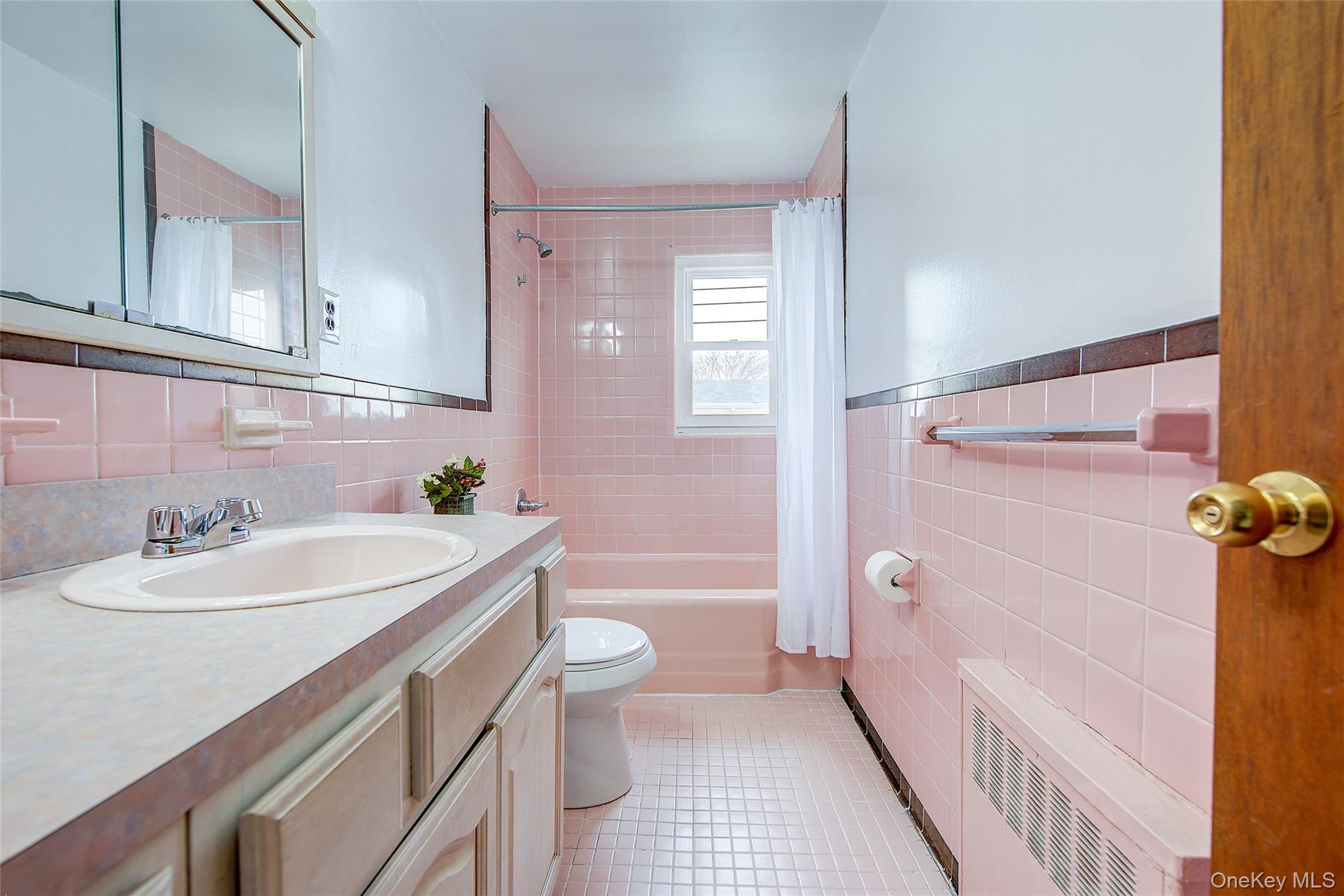 163-02 45th Avenue Queens, NY 11358 - Photo 11 of 35 Bathroom with shower / bath combo with shower curtain, tile walls, radiator heating unit, vanity, and light tile patterned floors