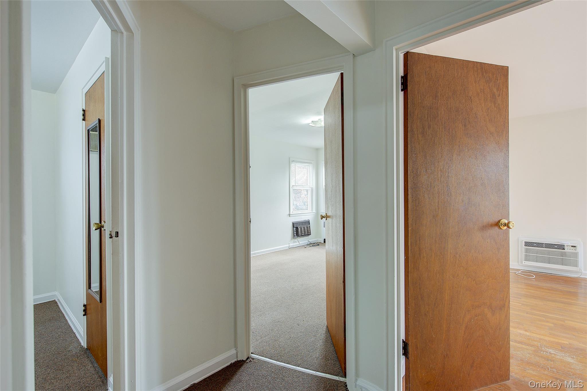 163-02 45th Avenue Queens, NY 11358 - Photo 13 of 35 Corridor with a wall mounted air conditioner and carpet flooring