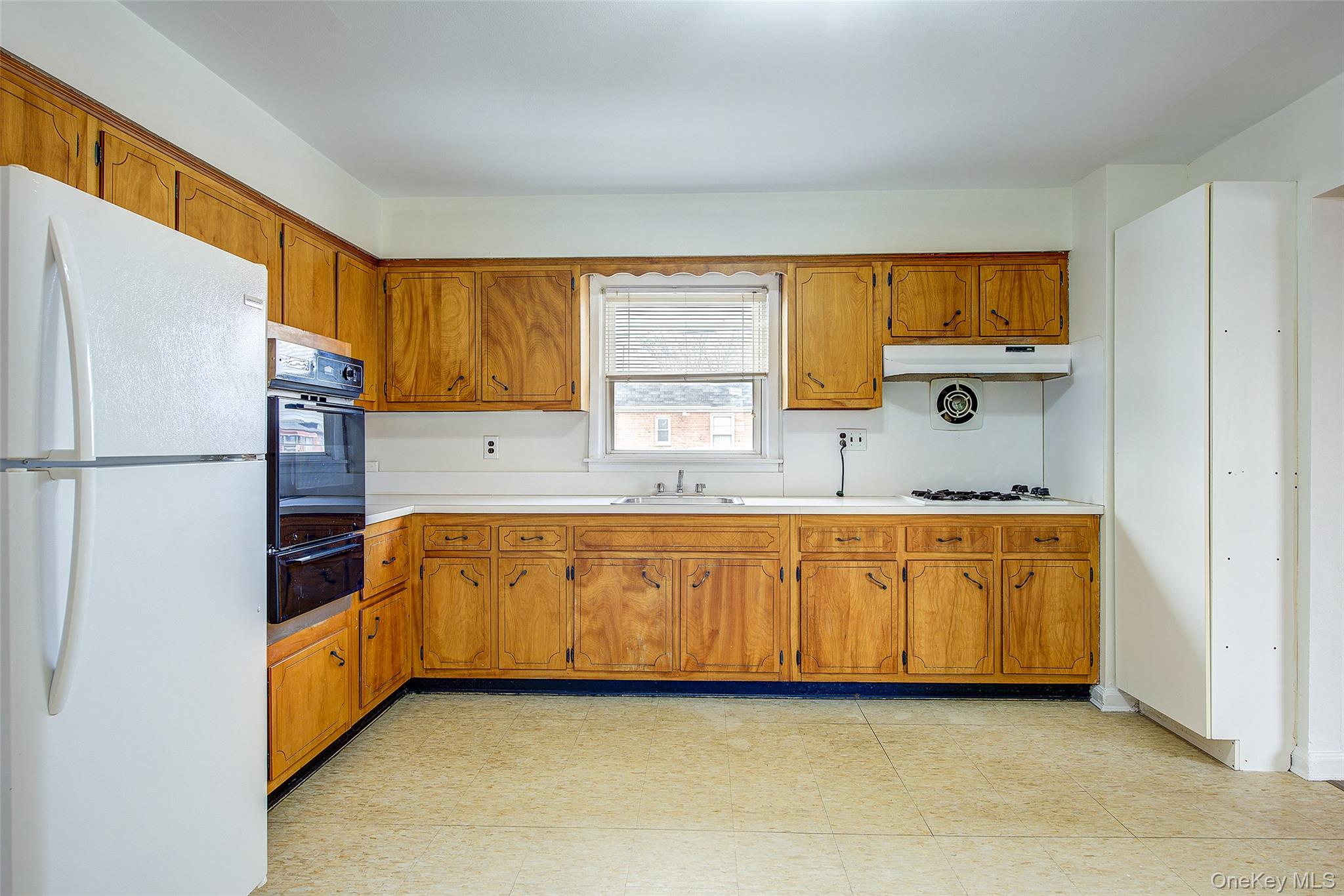 163-02 45th Avenue Queens, NY 11358 - Photo 10 of 35 Kitchen featuring freestanding refrigerator, light countertops, brown cabinetry, oven, and a warming drawer