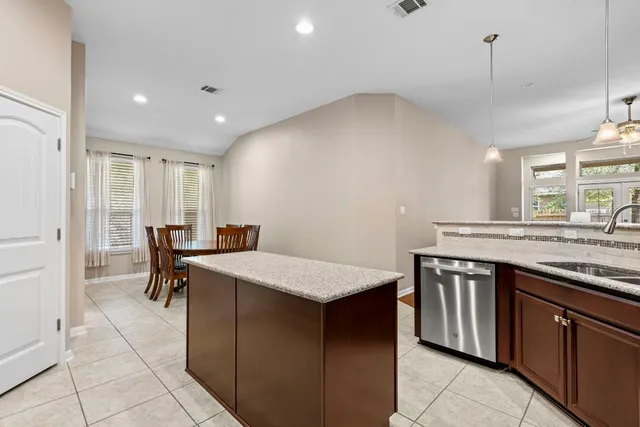 a kitchen with a stove a sink a dining table and chairs
