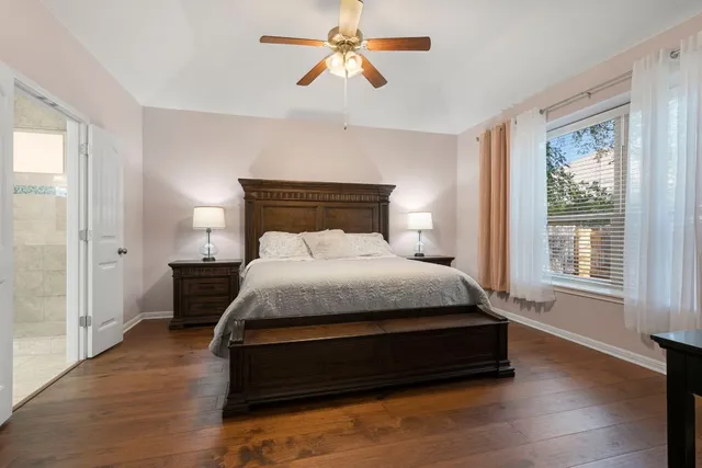a bedroom with a bed chandelier and a window