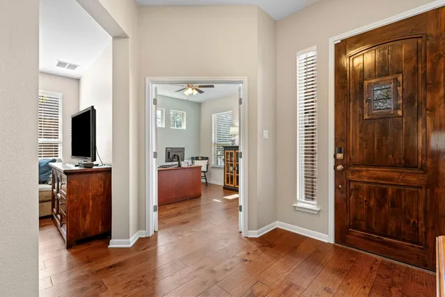 a view of a livingroom with wooden floor and a flat screen tv