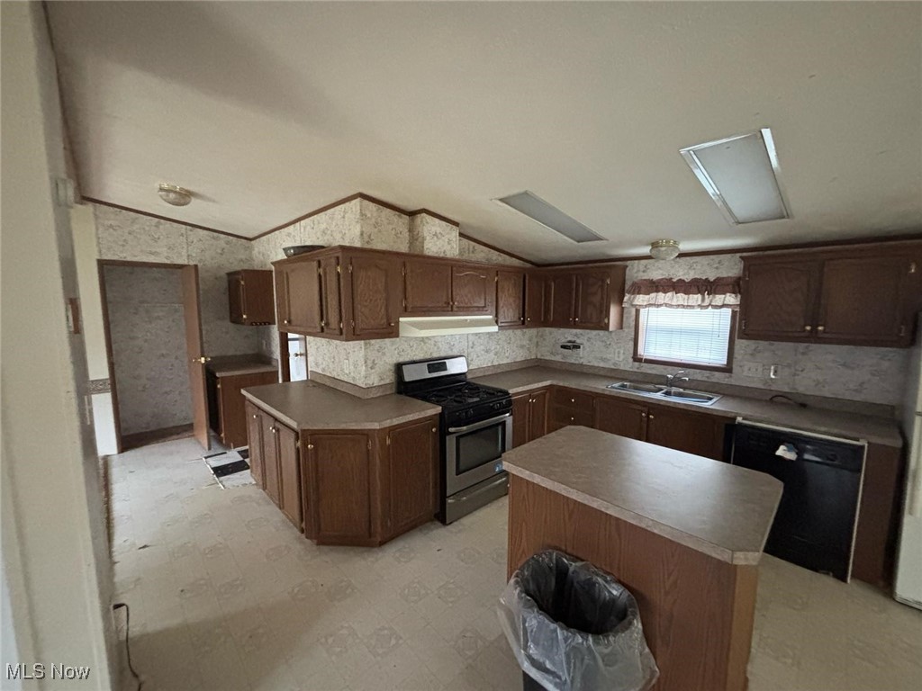 6829 Lee Road Newton Falls, OH 44444 - Photo 6 of 10 Kitchen featuring stainless steel range with gas cooktop, dishwasher, under cabinet range hood, a sink, and lofted ceiling