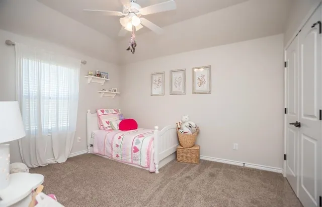 a bedroom with a bed window and a chandelier
