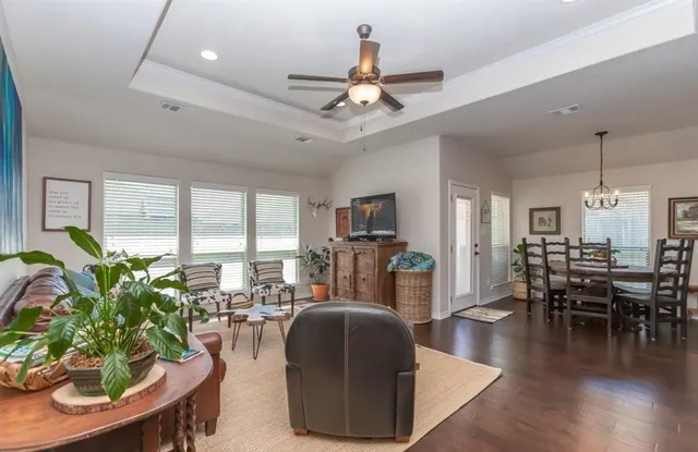 a living room with furniture dining area and a chandelier
