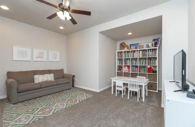 a living room with furniture and a book shelf