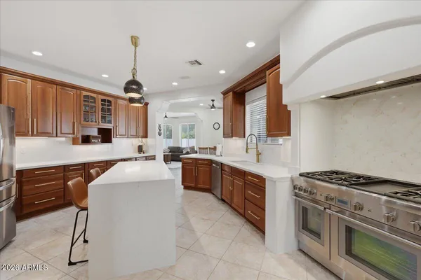 a large kitchen with stainless steel appliances granite countertop a stove a sink and a refrigerator