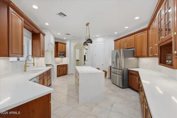 a large kitchen with stainless steel appliances granite countertop a sink and a refrigerator