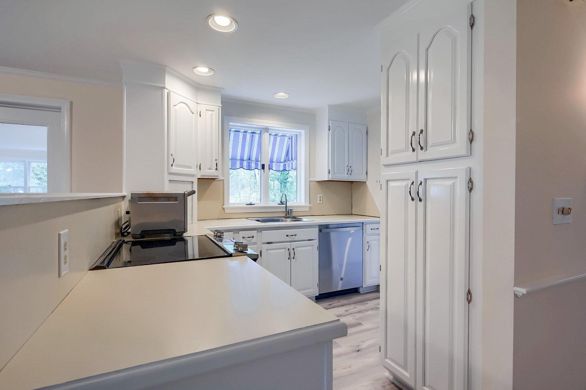 40 Barley Neck Road Orleans, MA 02653 - Photo 11 of 51 a kitchen with a refrigerator and white cabinets