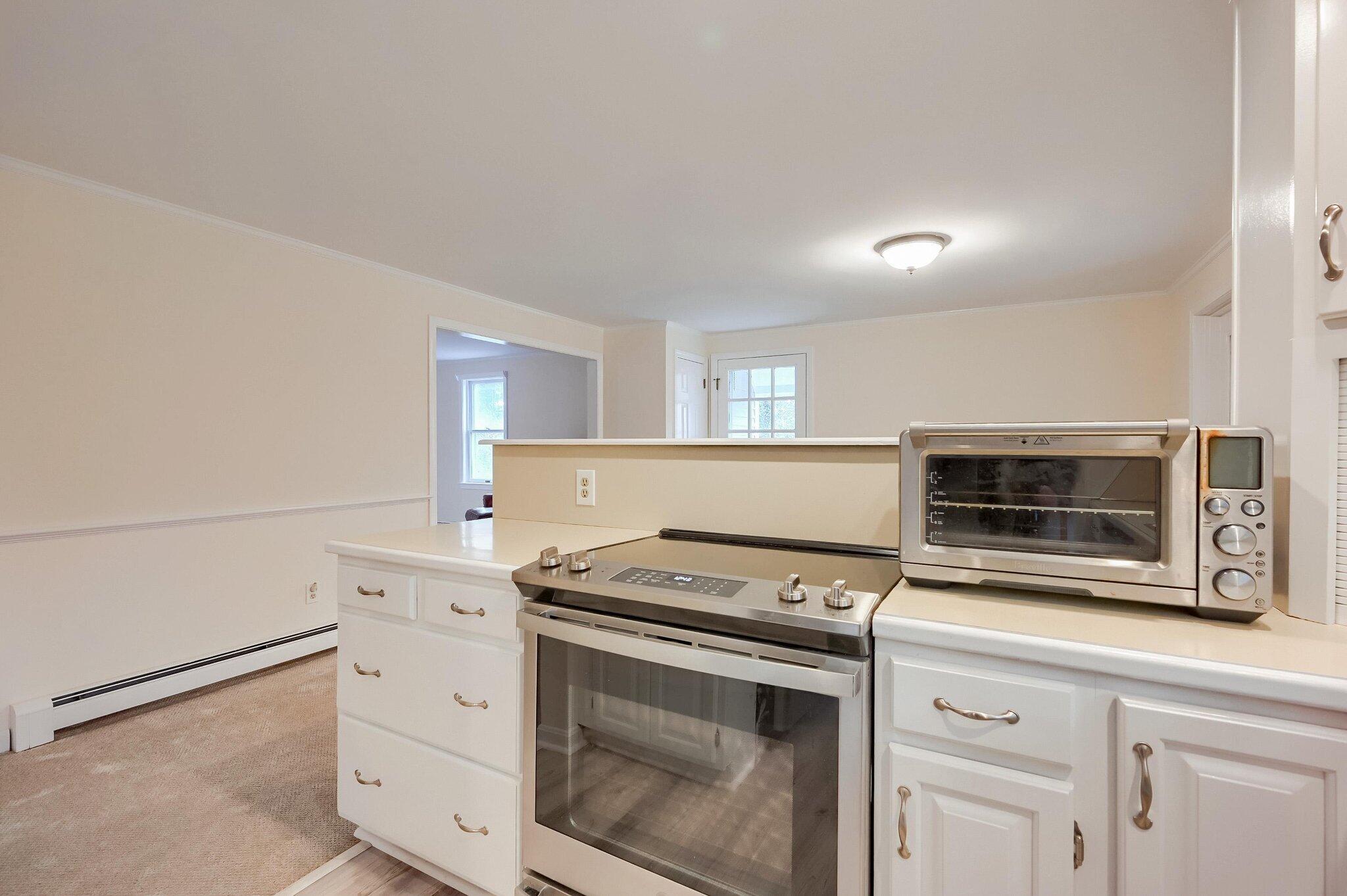 40 Barley Neck Road Orleans, MA 02653 - Photo 8 of 51 a kitchen with granite countertop white cabinets appliances and a sink