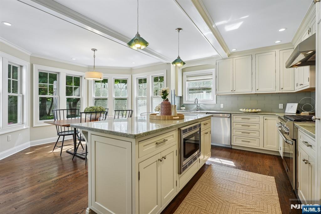 11 Mt Vernon Road Montclair, NJ 07043 - Photo 6 of 49 a kitchen with granite countertop a stove a sink a dining table and chairs with wooden floor