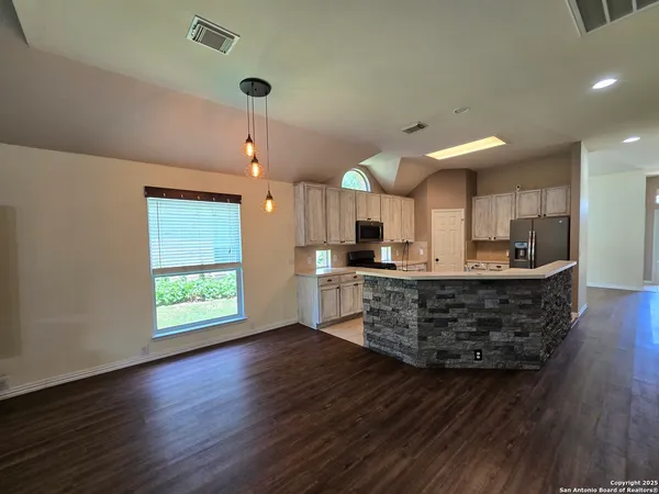 a kitchen with stainless steel appliances granite countertop a sink window and wooden floor