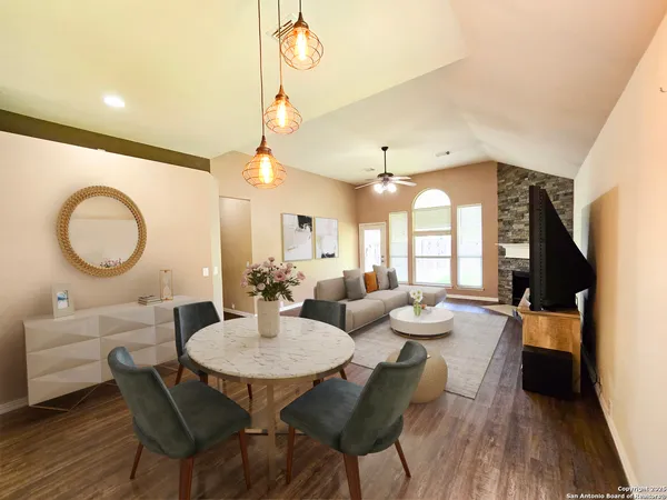a dining room with wooden floor a chandelier a wooden table and chairs