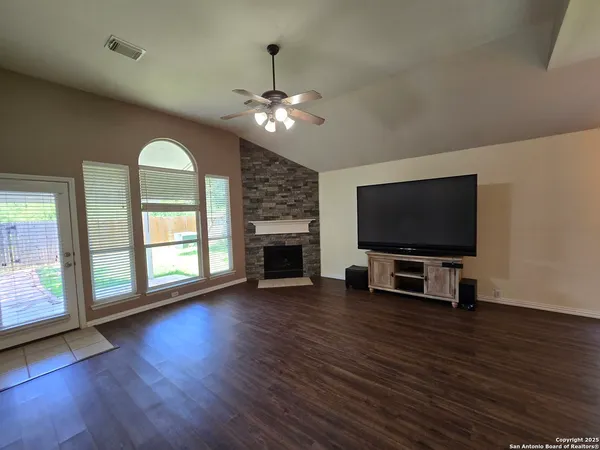 a living room with furniture a flat screen tv and a fireplace
