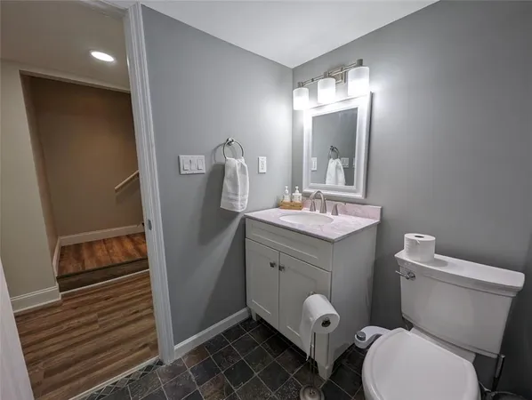 a bathroom with a toilet sink and mirror