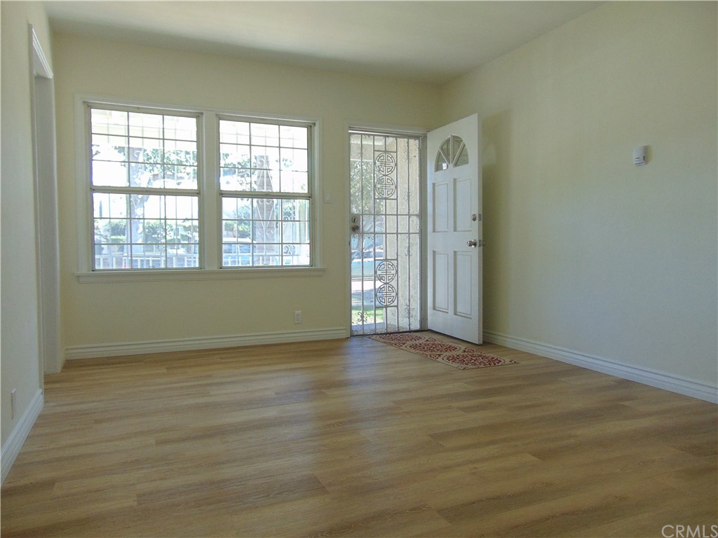 420 West 67th Way Long Beach, CA 90805 - Photo 2 of 21 an empty room with wooden floor and windows