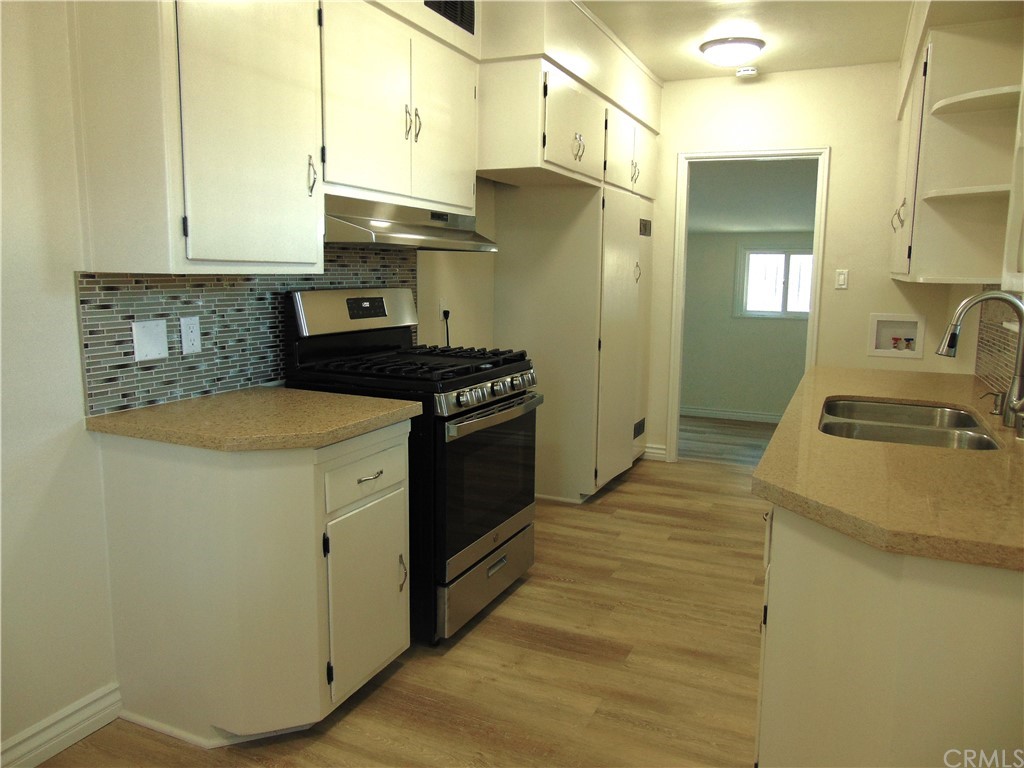 420 West 67th Way Long Beach, CA 90805 - Photo 4 of 21 a kitchen with a stove and a refrigerator