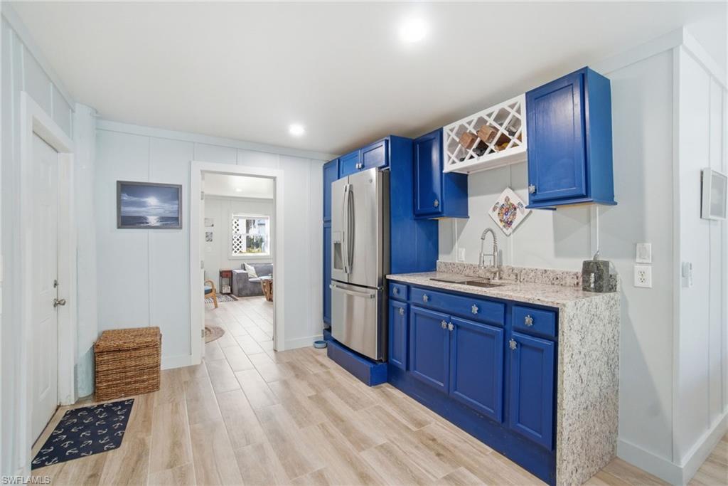 1286 Venetian Way Naples, FL 34110 - Photo 20 of 46 a kitchen with stainless steel appliances granite countertop a refrigerator a sink and wooden cabinets