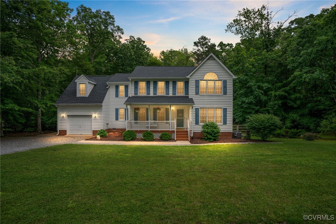 Colonial home featuring covered porch, driveway, a