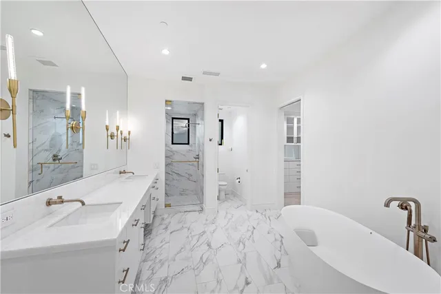 a bathroom with a tub a sink and mirror